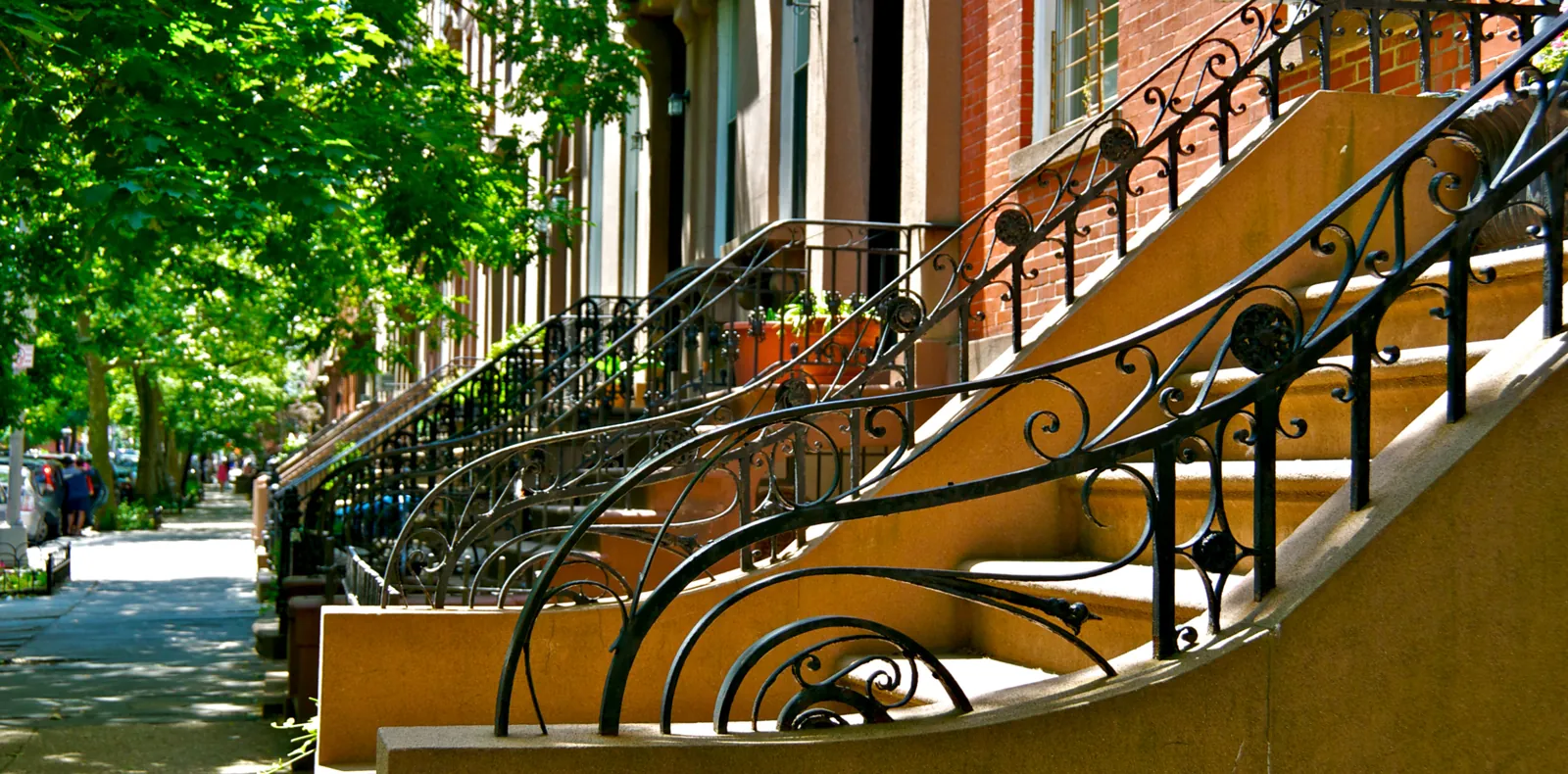 Brownstone stoops, iron railings and a tree-lined sidewalk in the supplied neighborhood photograph.