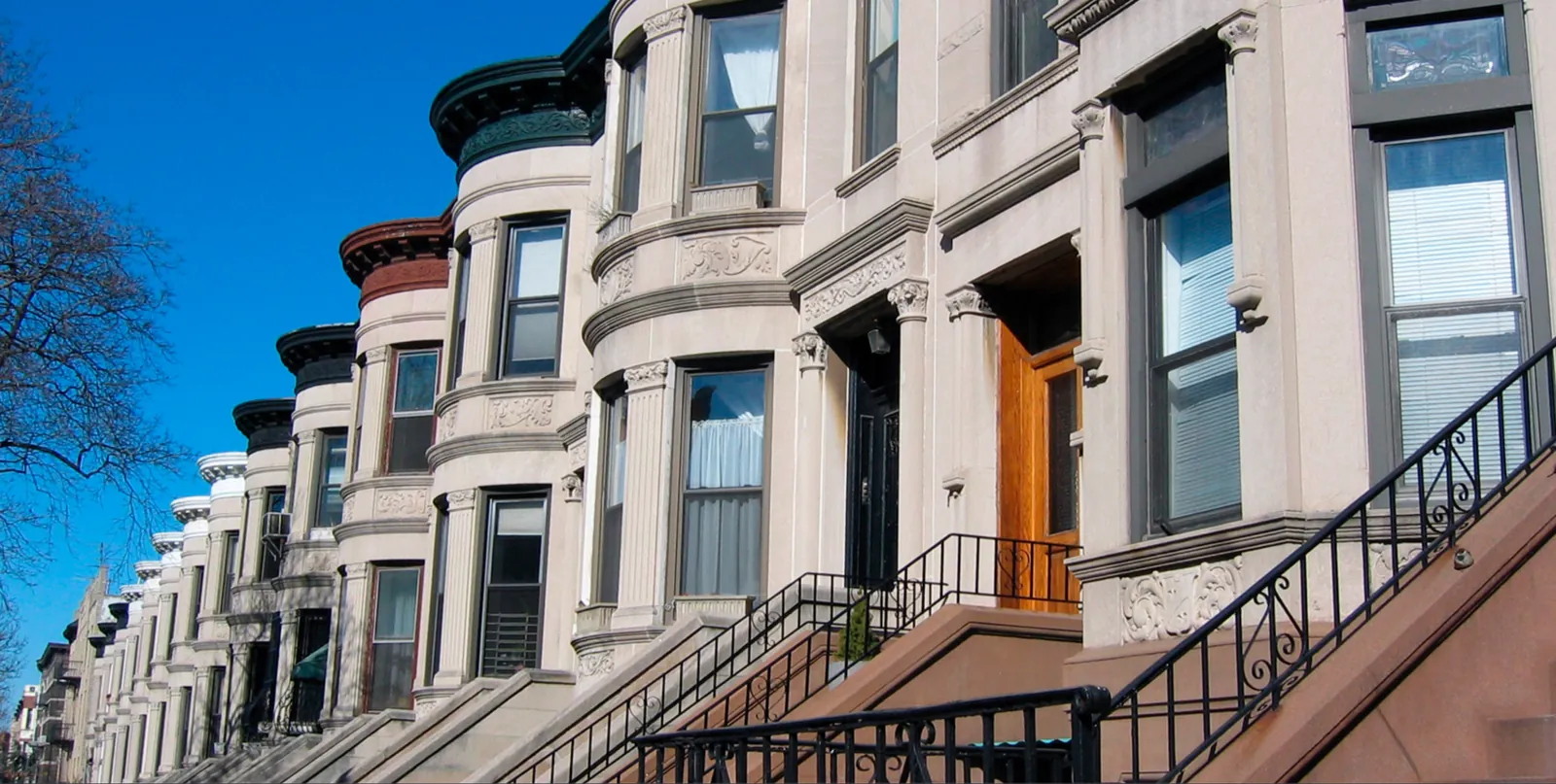 Bay-fronted row houses and stoops along a Park Slope street.
