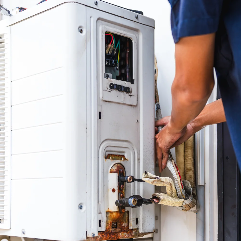 Technician inspecting an outdoor air conditioning unit.