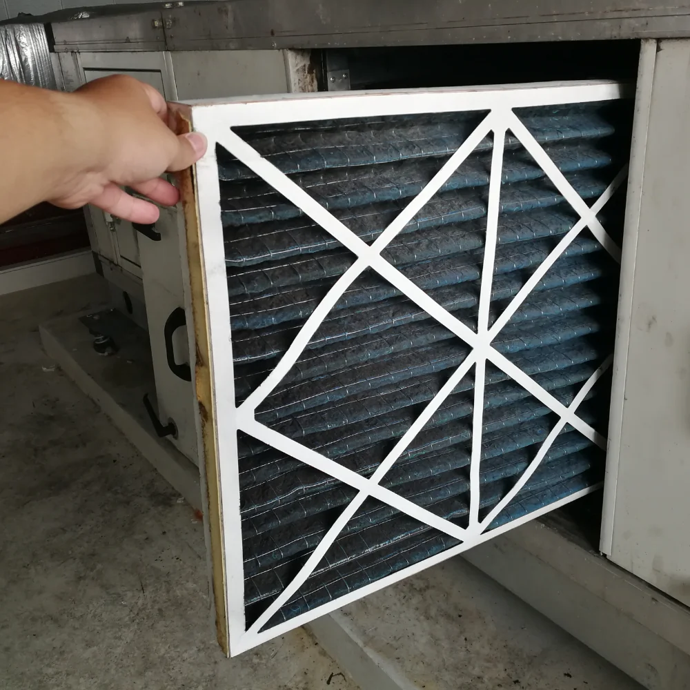 Filter being removed from an HVAC filter rack.