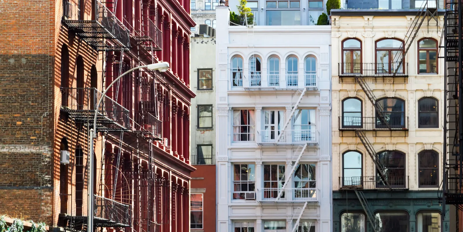 Cast-iron building fronts and fire escapes in the supplied SoHo streetscape photograph.