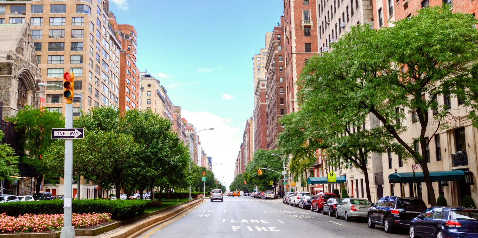 Apartment buildings, trees and a broad avenue in the supplied Upper East Side photograph.